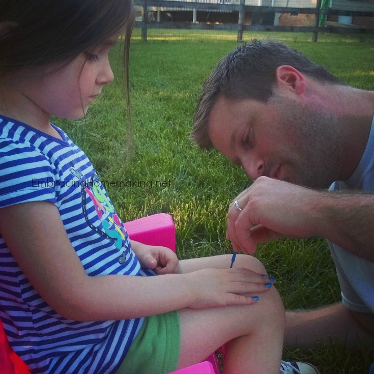 Dad painting daughter's nails
