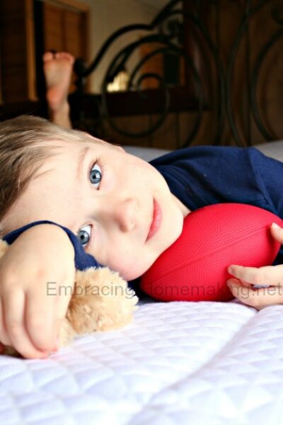 Boy on bed with toy football